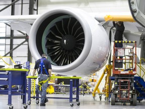 Employees work on a Bombardier Inc. CS300 airplane at the company's hangar in Mirabel, Quebec.