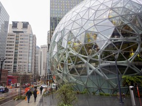 Pedestrians pass in front of the Amazon.com Inc. Spheres in Seattle, Washington.