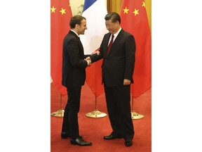 French President Emmanuel Macron shakes hands with Chinese President Xi Jinping during their meeting at the Great Hall of the People in Beijing, Jan. 9, 2018.