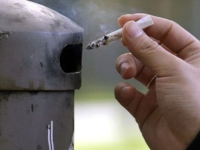 FILE - In this Oct. 27, 2015, file photo, a University of Washington student discards a cigarette into a container at a designated smoking locations on the campus in Seattle. Seventeen public health schools in the U.S. and Canada have pledged to refuse research money from a new anti-smoking group funded by the tobacco industry. Deans of public health schools at Harvard, Johns Hopkins and a dozen other schools said Thursday, Jan. 25, 2018, that the group is too closely tied to an industry that sells harmful products.