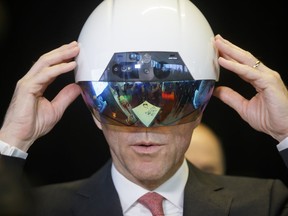 Bill Morneau, Canada's finance minister, tries on a virtual reality helmet.