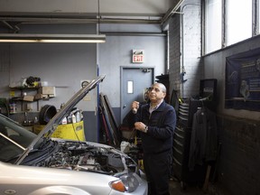 Mohamed Bouchama, consultant for Car Help Canada, checks the oil levels as he inspects a used car at a mechanic's garage in Toronto on Wednesday, January 10, 2018.