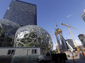 In this Oct. 11, 2017, file photo, large spheres take shape in front of an existing Amazon building, behind, as new construction continues across the street in Seattle.