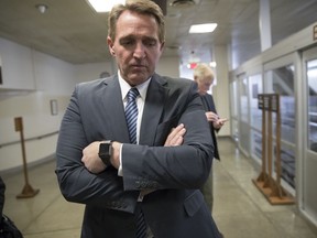 Sen. Jeff Flake, R-Ariz., waits for a subway ride back to the Capitol after he and a bipartisan group of moderate senators met privately on Day 2 of the federal shutdown, at the Capitol in Washington, Sunday, Jan. 21, 2018.
