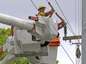 In this Monday, Oct. 2, 2017, photo, a Pike utility worker works on a power line in Miami. On Wednesday, Jan. 17, 2018, the Federal Reserve said U.S. industrial production rose 0.9 percent in December, pulled higher by a surge in utility output, another sign of health for the American economy.