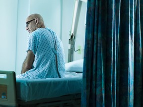 Senior man sitting on hospital bed