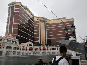 In this Aug. 17, 2016, photo, a man walks past Wynn Palace in Macau. The China arm of Steve Wynn's casino empire says it will comply with Macau regulators as they seek more information about sexual misconduct allegations against the Las Vegas billionaire.