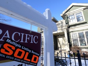 A real estate sold sign is shown outside a house in Vancouver.