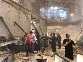 Indonesian security stand near the ruin of a structure inside the Jakarta Stock Exchange tower in Jakarta, Indonesia, Monday.