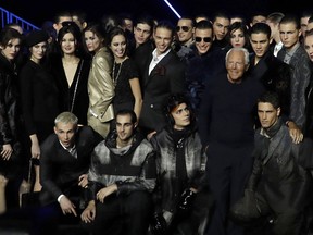 Designer Giorgio Armani, fourth from right, poses with models wears after the Emporio Armani men's Fall-Winter 2018-19 collection, that was presented in Milan, Italy, Saturday, Jan.13, 2018.