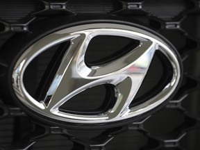 FILE - In this Oct. 26, 2017, file photo, the logo of Hyundai Motor Co. is seen on a car displayed at the automaker's showroom in Seoul, South Korea. Hyundai Motor Co. says it will release its first self-driving vehicles to markets by 2021 in partnership with U.S. self-driving technology startup Aurora Innovation Inc.