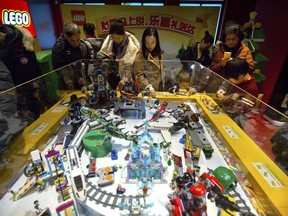 FILE - In this Saturday, Dec. 23, 2017 file photo, people look at a display of Lego creations at Hamleys toy store during its grand opening in Beijing. Toy maker Lego is partnering with China's internet giant Tencent to offer games, video and possibly a social network aimed at children. The private company based in Copenhagen, Denmark, said Monday, Jan. 15, 2018 that the deal would combine Lego's ability to create content with Tencent's distribution reach.
