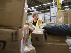Carla Qualtrough, Minister of Public Services and Procurement, looks through some mail after making an announcement regarding the vision for renewal at Canada Post, providing high quality service for Canadians at the Canada Post Gateway location in Mississauga, Ont., on Wednesday, January 24, 2018.