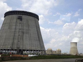 A cooling tower for a nuclear power plant reactor that's under construction stands near the two operating reactors at Plant Vogtle power plant in Waynesboro, Ga.