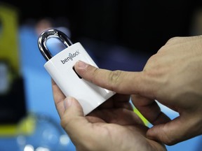 Junior Enrique demonstrates on the Benjilock, a rechargeable lock that uses fingerprint technology, during CES Unveiled at CES International Sunday, Jan. 7, 2018, in Las Vegas.