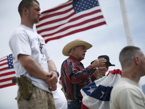 FILE - In this April 18, 2014, file photo, flanked by armed supporters, rancher Cliven Bundy speaks at a protest camp near Bunkerville, Nev. A U.S. judge who declared a mistrial two weeks ago could on Monday, Jan. 8, 2018, kill the much-watched criminal prosecution of the Nevada rancher accused of leading an armed uprising against federal authorities in April 2014. Chief U.S. District Judge Gloria Navarro's decision in Las Vegas is sure to echo among states' rights advocates in Western states where the federal government controls vast expanses that some people want to remain unused and others want open to grazing, mining and oil and gas drilling.