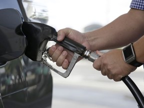 FILE - In this Jan. 23, 2015 file photo, a motorist refuels his vehicle at a Westar gas station in Miami.  Consumer inflation slowed in December 2017 to a tiny 0.1 percent gain as the cost of energy products tumbled after a big jump in November. The Labor Department says the December increase in consumer prices followed a much bigger 0.4 percent jump in November and was the smallest advance since a similar 0.1 percent rise in October.