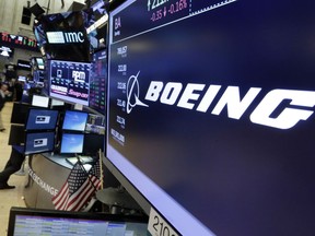 FILE - In this  July 24, 2017 file photo, the Boeing logo appears above a trading post on the floor of the New York Stock Exchange.  Boeing Co.  on Wednesday, Jan. 31, 2018,  reported fourth-quarter profit of $3.13 billion. The Chicago-based company said it had net income of $5.18 per share. Earnings, adjusted for pretax gains, came to $4.80 per share.