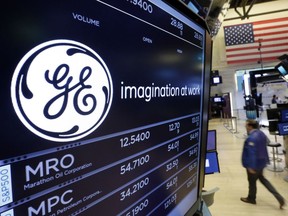 FILE - In this June 12, 2017, file photo, the General Electric logo appears above a trading post on the floor of the New York Stock Exchange. General Electric says it will take a $6.2 billion after-tax charge in the fourth quarter tied to its review and reserve testing of GE Capital's run-off insurance portfolio. GE Capital will also suspend its dividend to GE for the foreseeable future.