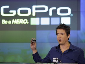 FILE - In this Thursday, June 26, 2014, file photo, GoPro CEO Nick Woodman celebrates his company's IPO at the Nasdaq MarketSite in New York. GoPro is cutting staff and expects a sharp decline in fourth-quarter revenue after facing weak demand for cameras during the 2017 holiday season. As part of the restructuring plan, Woodman will cut his 2018 cash compensation to $1. It was $800,000 in 2016.