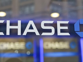 FILE - This Sept. 13, 2014, file photo, shows the Chase bank logo in New York. On Tuesday, Jan. 23, 2018, JPMorgan Chase said it is boosting hourly wages and opening new branches following recent earnings and tax cuts. The financial firm will also boost loan availability to potential homeowners and increase philanthropic giving.