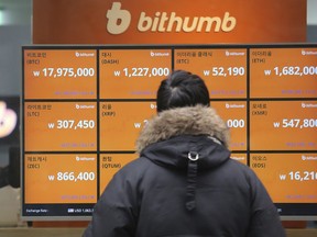 FILE - In this Tuesday, Jan. 16, 2018, file photo, a man watches a screen showing the prices of bitcoin at a virtual currency exchange office in Seoul, South Korea. Bitcoin is suffering another one of its trademark nosedives on Wednesday. The digital currency has fallen about 30 percent during the week as investors worry that regulators in South Korea will crack down on trading.