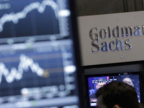 FILE - In this Oct. 16, 2014, file photo, a screen at a trading post on the floor of the New York Stock Exchange is juxtaposed with the Goldman Sachs booth. The Goldman Sachs Group, Inc. reports earnings Wednesday, Jan. 17, 2018.