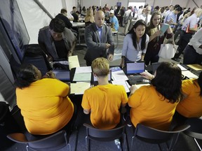 FILE - In this Wednesday, Aug. 2, 2017, file photo, job candidates are processed during a job fair at the Amazon fulfillment center in Robbinsville Township, N.J. On Friday, Jan. 5, 2018, the U.S. government issues the December jobs report.