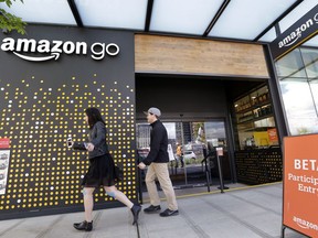 FILE - In this Thursday, April 27, 2017, file photo, people walk past an Amazon Go store in Seattle. More than a year after it introduced the concept, Amazon is opening its artificial intelligence-powered Amazon Go store in downtown Seattle on Monday, Jan. 22, 2018.