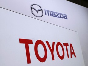 FILE- In this Aug. 4, 2017, file photo, logos of Toyota Motor Corp., bottom, and Mazda Motor Corp., top, are placed prior to a news conference in Tokyo. Japanese automakers Toyota and Mazda have picked Alabama as the site of a new $1.6 billion joint-venture auto manufacturing plant, a person briefed on the decision said Tuesday, Jan. 9, 2018.