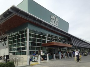 In this Jan. 17, 2018 photo, customers exit a Whole Foods Market in North Miami, Fla. When Amazon sets its sights on a new industry, corporate America shudders. On Tuesday, Jan. 30, 2018, when the online retailing giant said it is working with Berkshire Hathaway and JPMorgan Chase to create a health care company to offer an "affordable" option to their employees, stocks of health insurers tumbled. Last year supermarket stocks slumped when Amazon unexpectedly bought Whole Foods.