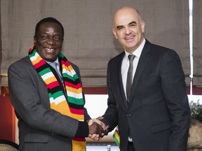 Swiss Federal President Alain Berset, right, and Zimbabwe's President Emmerson Mnangagwa, left, shake hands during a bilateral meeting at the 48th Annual Meeting of the World Economic Forum, WEF, in Davos, Switzerland, Thursday, Jan. 25, 2018. The meeting brings together entrepreneurs, scientists, corporate and political leaders in Davos, January 23 to 26.