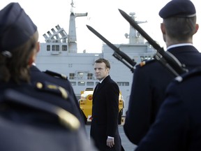 French President Emmanuel Macron reviews an honor guard upon his arrival on board the the Dixmude, an amphibious assault ship, docked in the French Navy base of Toulon, southern France, before delivering a speech to present his New Year's wishes to the French Army, Thursday, Jan. 19, 2018.