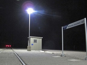 This Friday, Dec. 29, 2017 photo, shows the Amtrak station at Williams Junction outside Williams, Ariz., with little else beside an asphalt platform, lighting, signage and a storage building. Shuttle service between the junction and Williams ended Monday, Jan. 1, 2018, effectively shutting down the bare-bones station where passengers step onto a dimly lit asphalt platform in a forest clearing.