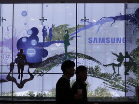 People pass by Samsung Electronics' shop in Seoul, South Korea, Wednesday, Jan. 31, 2018. The craze for smartphones, social media and universal connectivity is generating immense wealth but also deep unease in South Korea, source of a large share of the computer chips that make them work. Soaring demand for microchips used in smartphones, computer servers and data centers is driving profits for chip and smartphone maker Samsung Electronics and its smaller rival SK Hynix sky high, helping sustain growth in Asia's fourth largest economy.