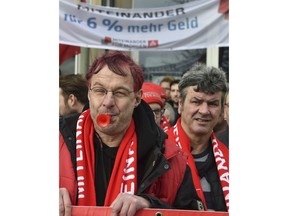 In this Jan. 24, 2018 photo, metal workers protest during a warning strike in Ludwigsfelde, Germany. The head of Germany's largest industrial workers' union says strikes could escalate if no deal for a new labor agreement can be reached by noon Saturday. Joerg Hoffmann said Friday Jan. 26, 2018 that the IG Metall union was talking again with employers in the southern industrial region of Baden-Wuerttemburg, where any deal would be expected to set the example for 3.9 million workers across the country.