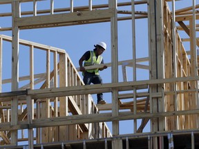 In this Friday, Oct. 6, 2017, photo, workers build an apartment and retail complex in Nashville, Tenn. On Friday, Jan. 26, 2018, the Commerce Department issues the first estimate of how the U.S. economy performed in the October-December quarter.