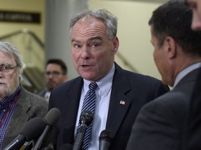 FILE - In this April 7, 2017, file photo, Sen. Tim Kaine, D-Va., center, speaks to reporters on Capitol Hill in Washington. Democrats say they're shifting to offense on health care, emboldened by successes in defending the Affordable Care Act. They say their ultimate goal is a government guarantee of affordable coverage for all.