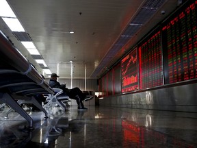 A man checks stock index through his smartphone at a brokerage house in Beijing, Monday, Jan. 8, 2017. Asian stock markets rose Monday following Wall Street's strong week as traders looked ahead to data releases from China, Japan and the Eurozone.