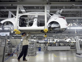In this Feb. 21, 2017, photo, a staff member works on an assembly line at a Beijing Hyundai Motor auto plant in Cangzhou in northern China's Hebei province. An industry group says China's auto sales shrank in December and ended 2017 up just 1.4 percent over the previous year as the popularity of SUVs helped to offset contraction in demand for sedans. (Chinatopix via AP)