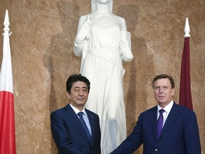 Japanese Prime Minister Shinzo Abe, left, and Latvian Prime Minister Maris Kucinskis shake hands as they pose for a photo prior to their talks in Riga, Latvia, Saturday, Jan. 13, 2018. Abe is on a visit to three Baltic countries, Estonia, Latvia and Lithuania.