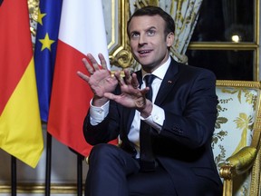 France's President Emmanuel Macron, gestures, during his meeting with German Chancellor Angela Merkel, at the Elysee Palace, in Paris, Friday, Jan. 19, 2018.