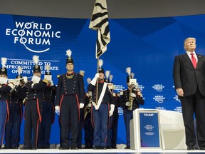 U.S. President Donald Trump, right, stands next to "The Landwehr of Fribourg", a historic marching band before addressing a plenary session during the 48th Annual Meeting of the World Economic Forum, WEF, in Davos, Switzerland, Friday, Jan. 26, 2018.