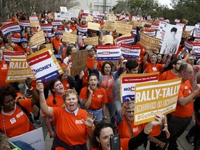 Activists hold up signs at the Florida State Capitol as they rally for gun reform legislation in Tallahassee, Florida.