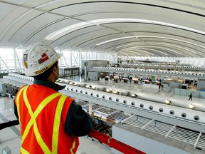 An Aecon Construction scissor lift operator works at Toronto Pearson International Airport.