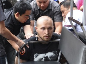 In this Friday, Feb. 2, 2018, photo released by the Crime Suppression Division of the Thailand Police, Sergey Medvedev, 31, center, is arrested outside an apartment in his role in an international identity theft ring that sold stolen credit card information on the dark web, leading to losses of over $530 million. (Crime Suppression Division of the Thailand via AP)