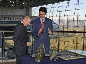 Canadian Prime Minister Justin Trudeau, right, is shown gifts that were given to President Ronald Reagan from Canada by Executive Director of the Ronald Reagan Presidential Foundation and Institute John Heubusch, Friday, Feb. 9, 2018, in Simi Valley, Calif.