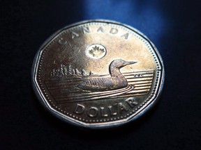 A Canadian dollar is pictured in North Vancouver, B.C. Wednesday, March 5, 2014. The Toronto Stock Exchange's S&P/TSX composite index was down 35.65 points to 15,416.99, after 90 minutes of trading.