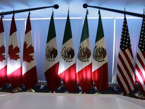 National flags representing Canada, Mexico, and the U.S. are lit by stage lights at the North American Free Trade Agreement, NAFTA, renegotiations, in Mexico City, Tuesday, Sept. 5, 2017. International Trade Minister Francois-Philippe Champagne is briefing senators on Canada's participation in the new Trans-Pacific Partnership trade pact.