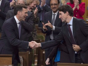 Finance Minister Bill Morneau shakes hands with Prime Minister Justin Trudeau after delivering his fall economic statement in the House of Commons in Ottawa, Tuesday, Oct.24, 2017. The Liberals are paving the road to the next election with a mid-mandate focused on fulfilling some on-brand promises, while potentially saving room for bigger, flashier items to come closer to the vote.